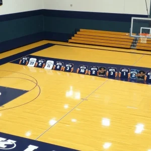 Basketball court with jerseys and recruitment signs displayed.