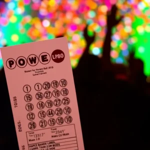 A Powerball ticket surrounded by colorful confetti celebrating a $100,000 win